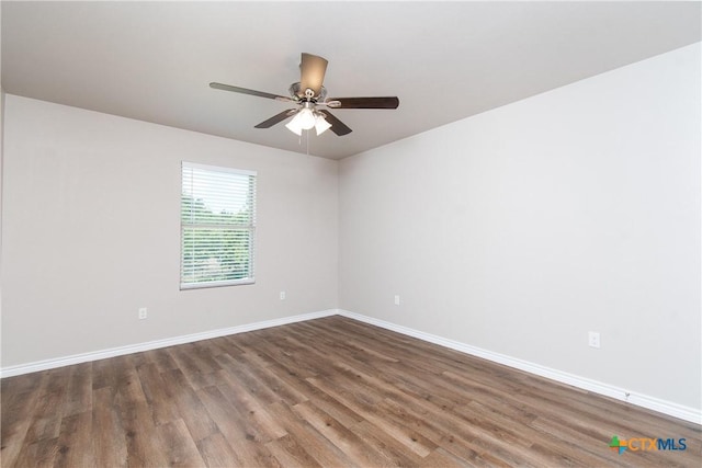 spare room featuring ceiling fan and dark wood-type flooring