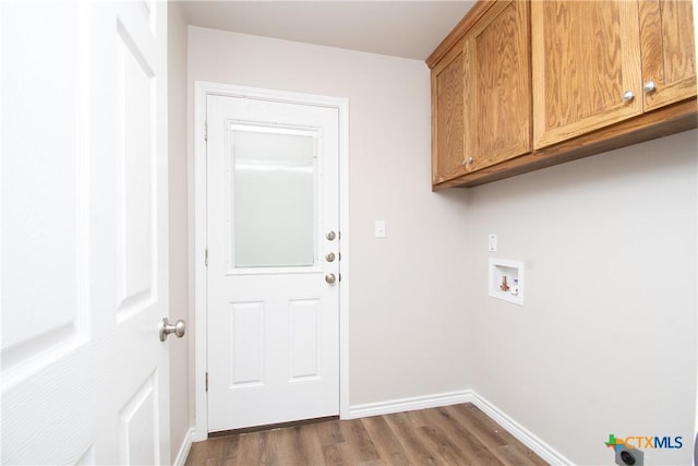 laundry room featuring dark wood-type flooring, hookup for a washing machine, and cabinets