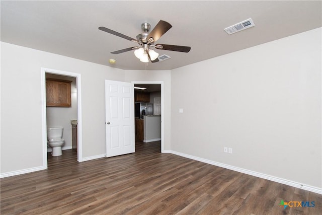 unfurnished bedroom featuring ensuite bath, ceiling fan, and dark wood-type flooring