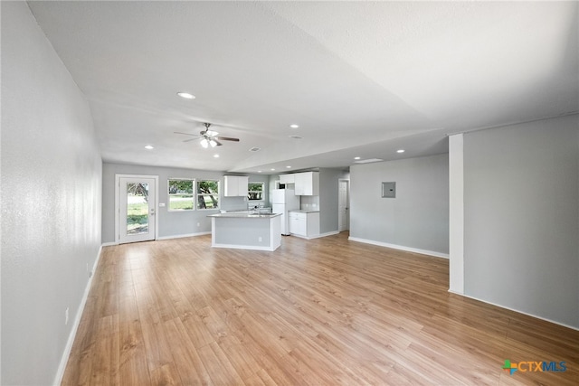 unfurnished living room featuring ceiling fan and light hardwood / wood-style flooring