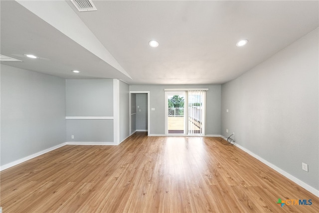 spare room featuring light hardwood / wood-style flooring and lofted ceiling