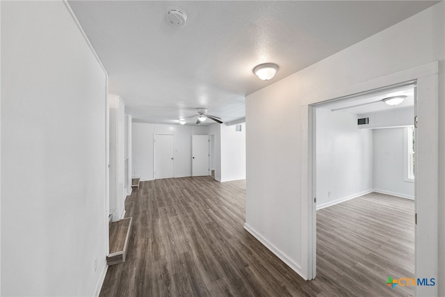 hall featuring a textured ceiling and dark hardwood / wood-style floors