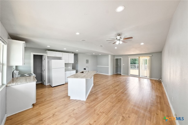 kitchen with a kitchen island, white refrigerator, range, white cabinets, and light hardwood / wood-style flooring