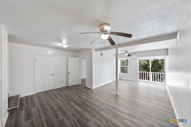 spare room with dark wood-type flooring, a textured ceiling, and ceiling fan