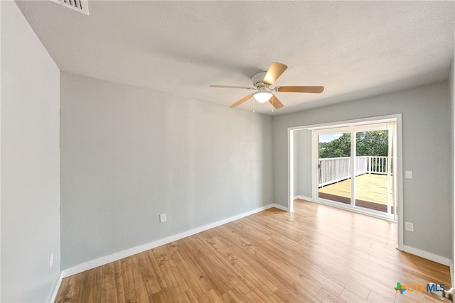 empty room with ceiling fan, a textured ceiling, and light wood-type flooring