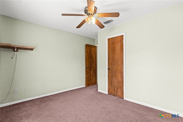 unfurnished bedroom with ceiling fan, baseboards, carpet flooring, and visible vents
