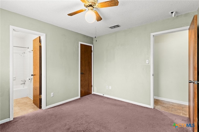 unfurnished bedroom featuring baseboards, visible vents, carpet, and a textured ceiling