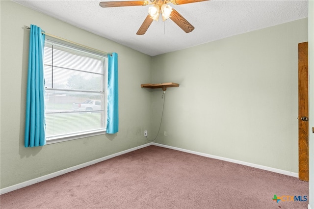 carpeted spare room with a textured ceiling, baseboards, and ceiling fan