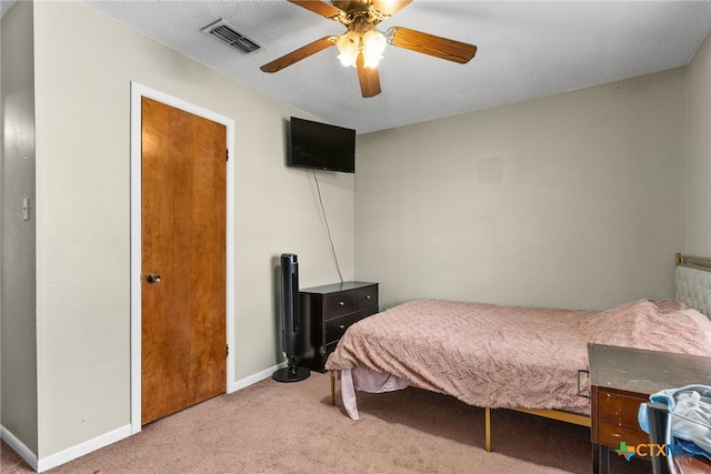 bedroom with a textured ceiling, carpet, and ceiling fan