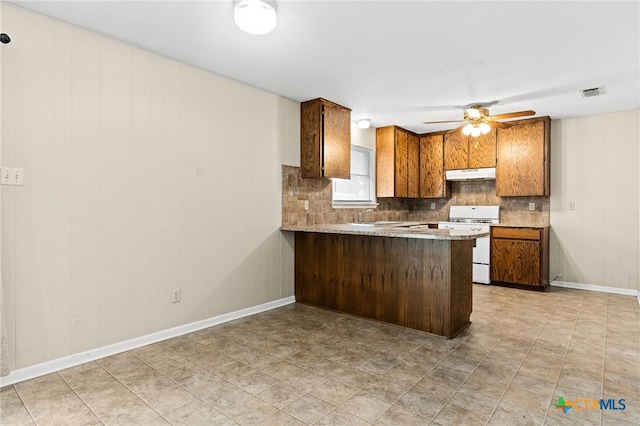 kitchen featuring under cabinet range hood, visible vents, a sink, white gas stove, and tasteful backsplash
