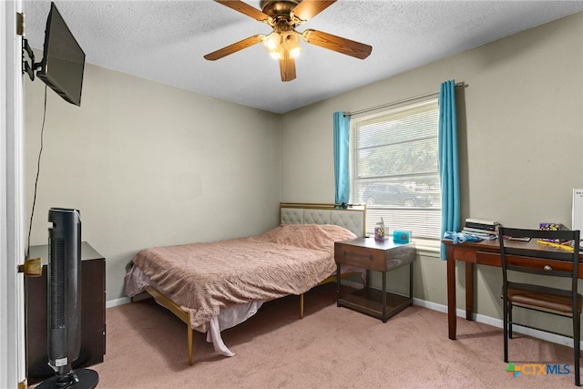 bedroom featuring a textured ceiling, light carpet, and ceiling fan