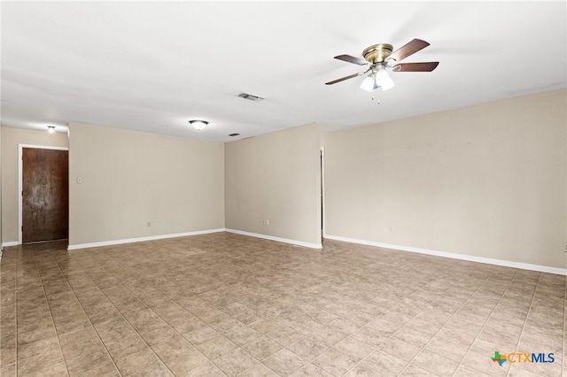 empty room with baseboards, a ceiling fan, and visible vents
