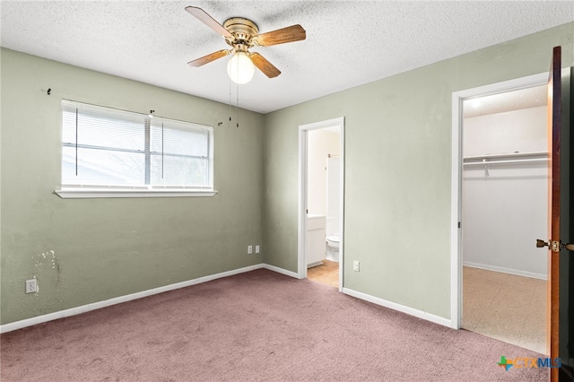 unfurnished bedroom featuring a closet, carpet, a textured ceiling, and baseboards