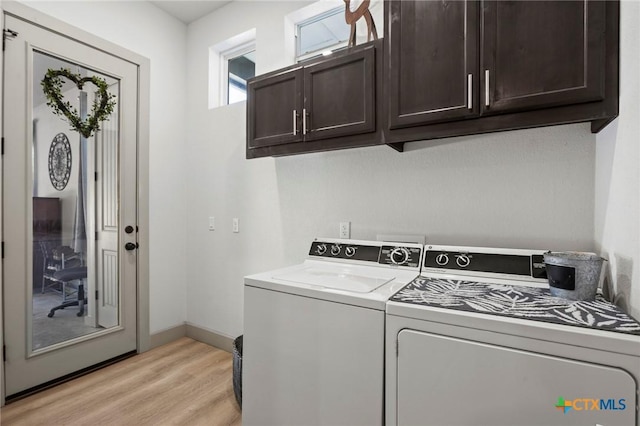 laundry area featuring cabinets, light hardwood / wood-style floors, and washing machine and dryer