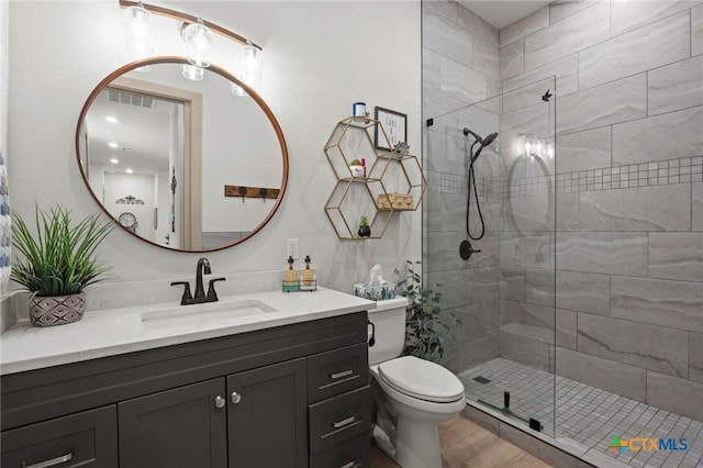 bathroom featuring vanity, an enclosed shower, and toilet