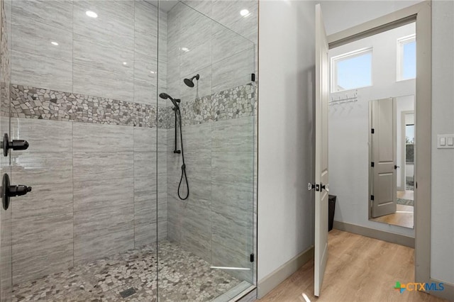 bathroom with hardwood / wood-style flooring and a tile shower