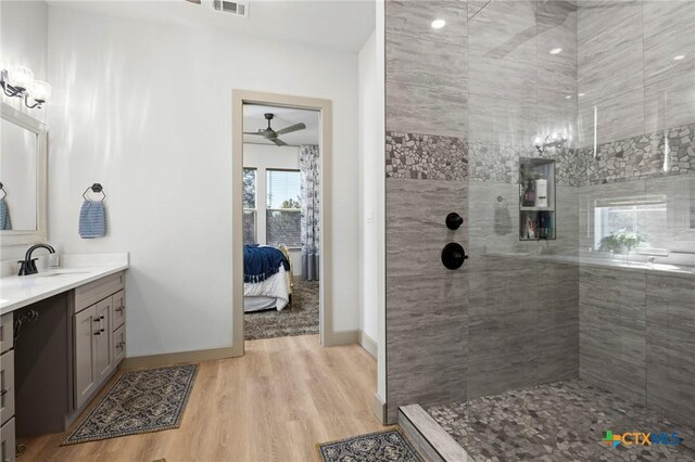 bathroom featuring vanity, hardwood / wood-style flooring, and tiled shower