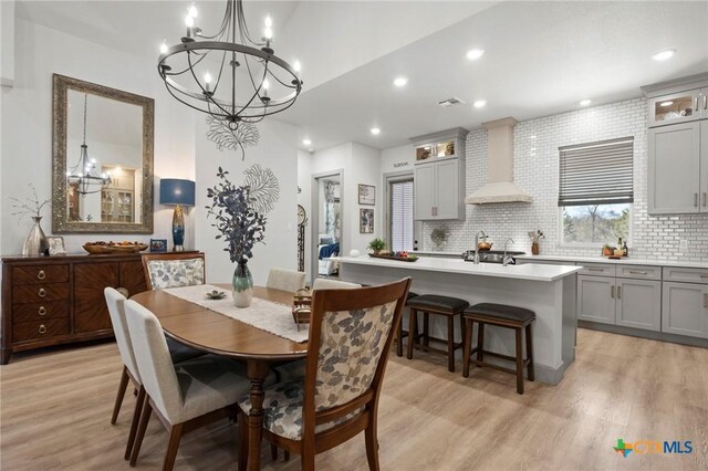 dining space featuring a notable chandelier and light wood-type flooring