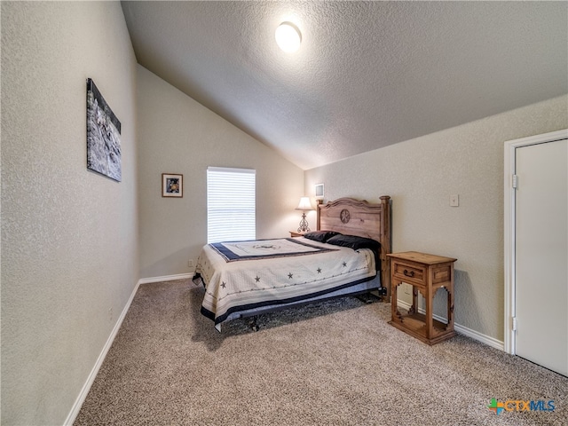 bedroom featuring vaulted ceiling, carpet flooring, and a textured ceiling