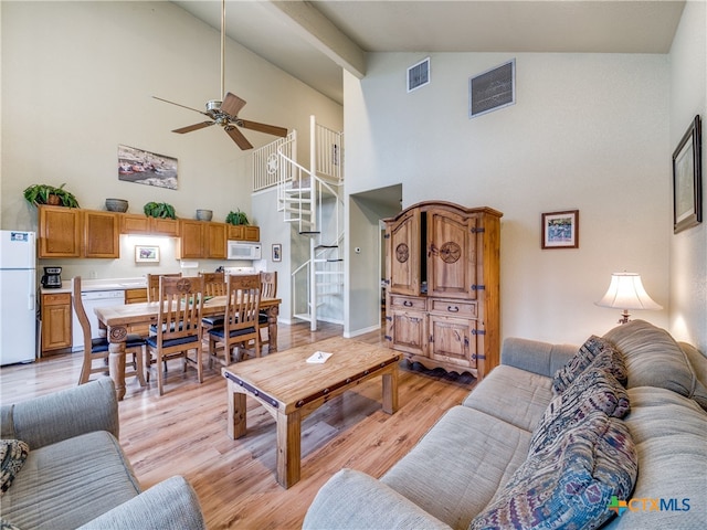 living room featuring ceiling fan, high vaulted ceiling, and light hardwood / wood-style floors