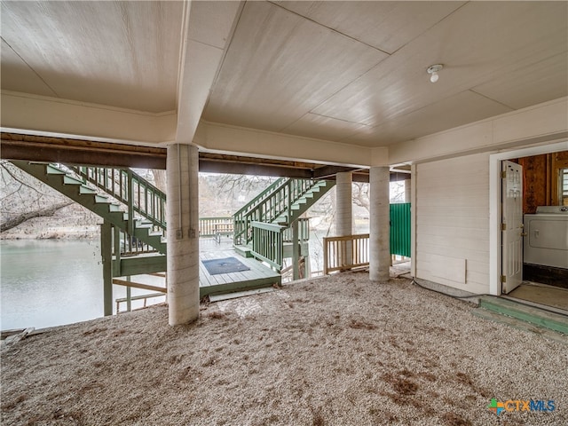 interior space featuring a water view, carpet flooring, and washer / dryer