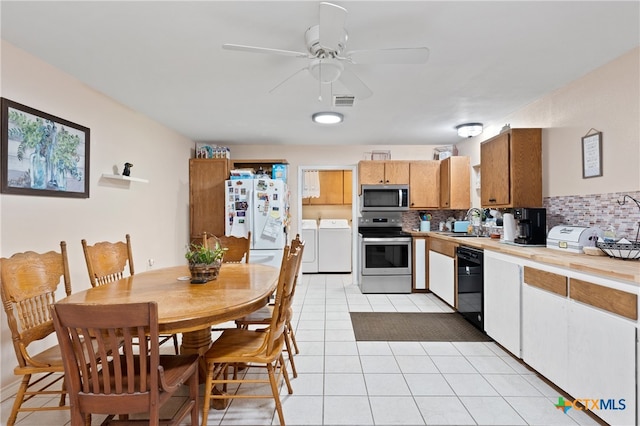 kitchen with stainless steel appliances, decorative backsplash, sink, washing machine and clothes dryer, and ceiling fan