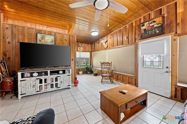 tiled living room featuring vaulted ceiling, wooden walls, ceiling fan, and wood ceiling