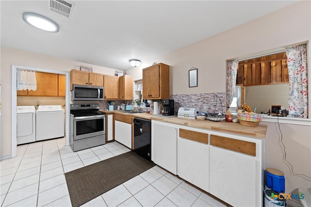 kitchen featuring stainless steel appliances, washing machine and dryer, sink, and tasteful backsplash