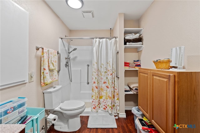 bathroom with walk in shower, toilet, and hardwood / wood-style flooring