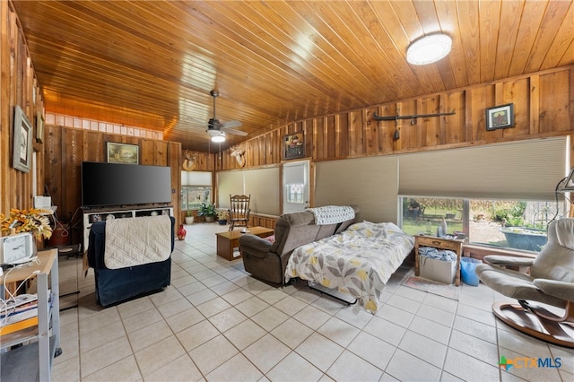 bedroom with vaulted ceiling, wooden walls, light tile patterned floors, wooden ceiling, and ceiling fan