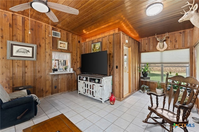 tiled living room with wooden walls, ceiling fan, and wooden ceiling