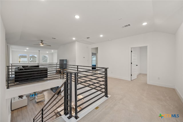 hall featuring light colored carpet and vaulted ceiling