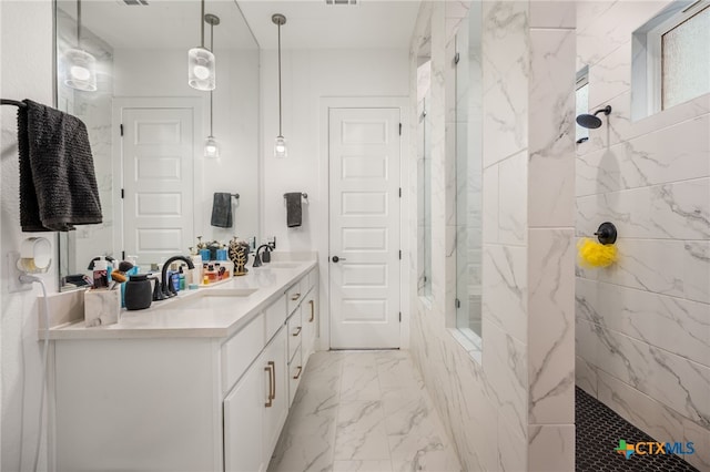 bathroom featuring a tile shower and vanity