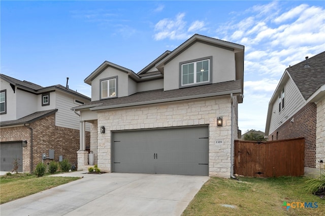 view of property featuring a garage and a front lawn