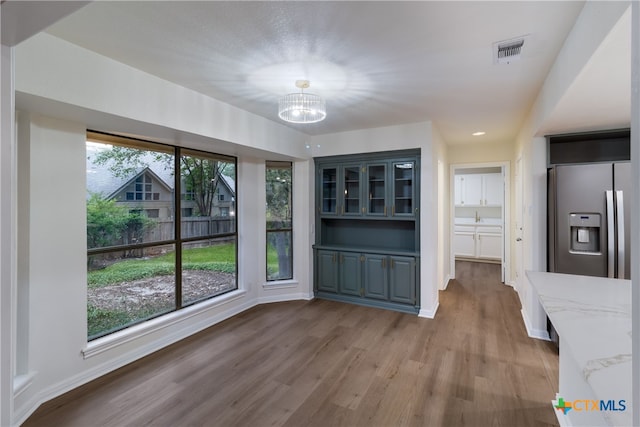 9215 Standing Creek Ln, San Antonio, TX 78230 - unfurnished dining area featuring a chandelier, wood finished floors, and baseboards