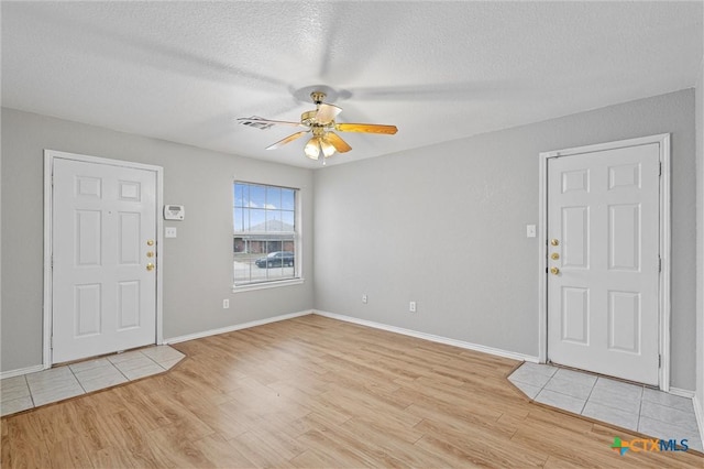 entryway featuring ceiling fan, light hardwood / wood-style floors, and a textured ceiling