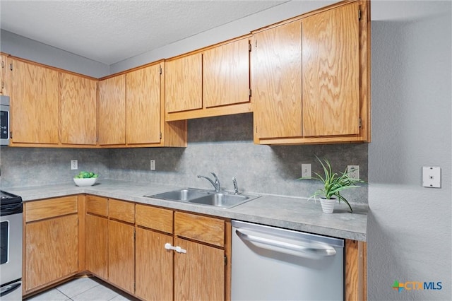 kitchen featuring backsplash, sink, light tile patterned floors, and appliances with stainless steel finishes