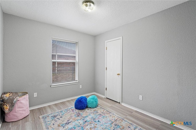 interior space with light hardwood / wood-style flooring and a textured ceiling