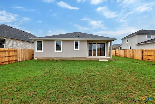 back of house with a lawn