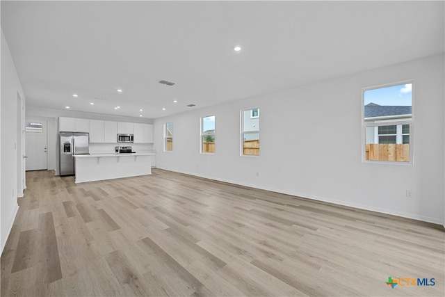 unfurnished living room featuring light hardwood / wood-style floors and plenty of natural light