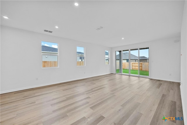 spare room featuring plenty of natural light and light wood-type flooring