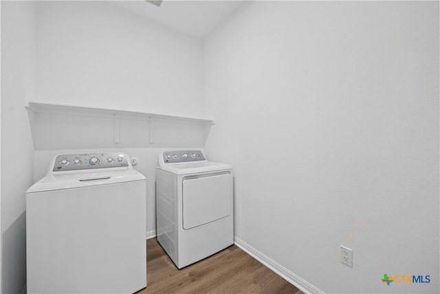 laundry room featuring light wood-type flooring and washing machine and clothes dryer