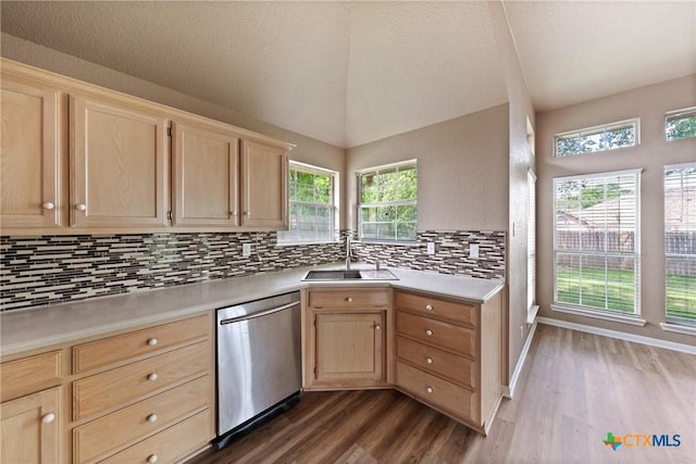 kitchen featuring tasteful backsplash, dishwasher, a sink, light countertops, and light brown cabinets