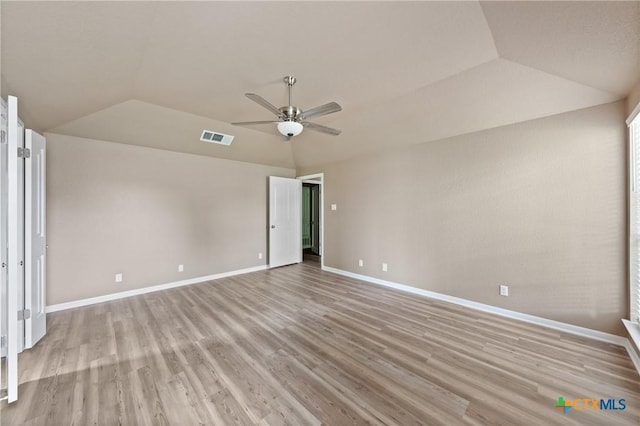 unfurnished room with light wood-style floors, a ceiling fan, baseboards, vaulted ceiling, and visible vents
