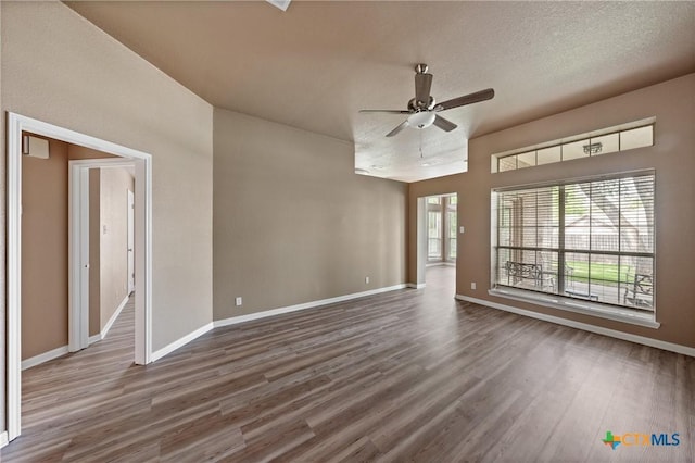 empty room featuring baseboards, ceiling fan, and wood finished floors