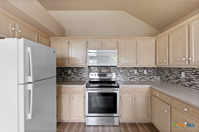 kitchen featuring light brown cabinetry, vaulted ceiling, light wood-type flooring, light countertops, and white appliances