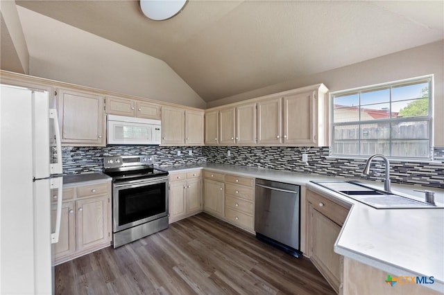 kitchen featuring appliances with stainless steel finishes, light countertops, wood finished floors, lofted ceiling, and tasteful backsplash