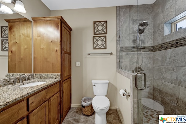 bathroom with a shower with shower door, vanity, and toilet