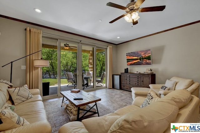 living room with ornamental molding, light hardwood / wood-style flooring, and ceiling fan