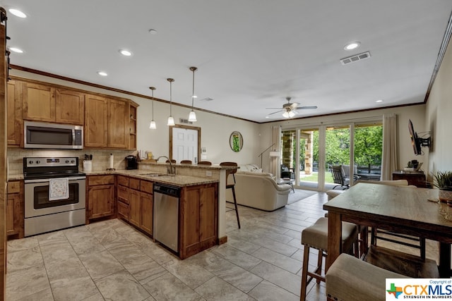 kitchen featuring stainless steel appliances, decorative light fixtures, light stone countertops, kitchen peninsula, and ceiling fan